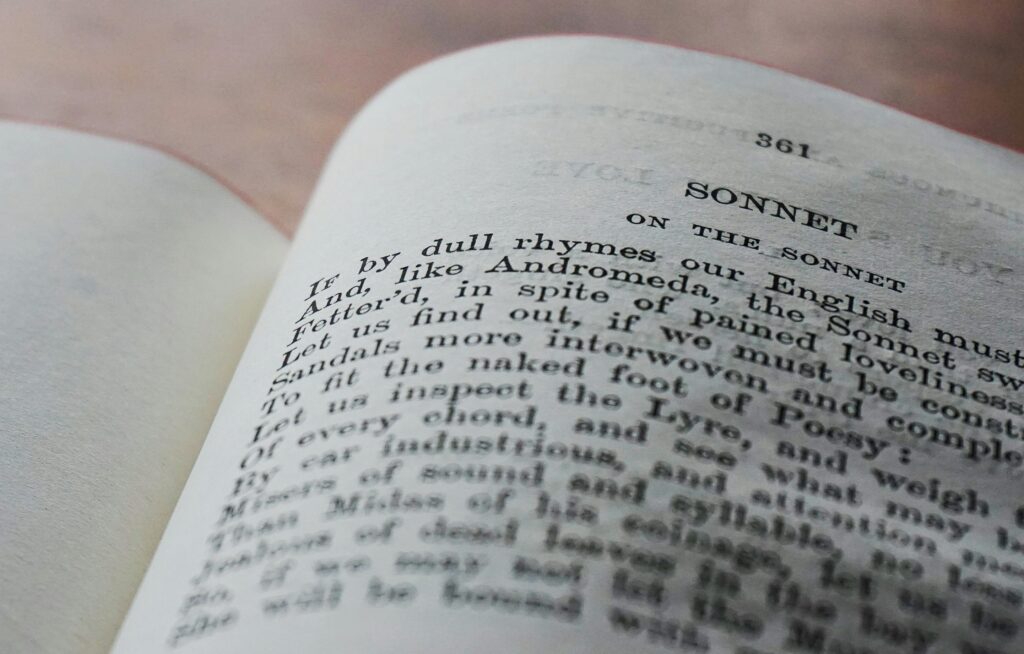 Close-up of an open book page displaying a classic English sonnet in black and white.